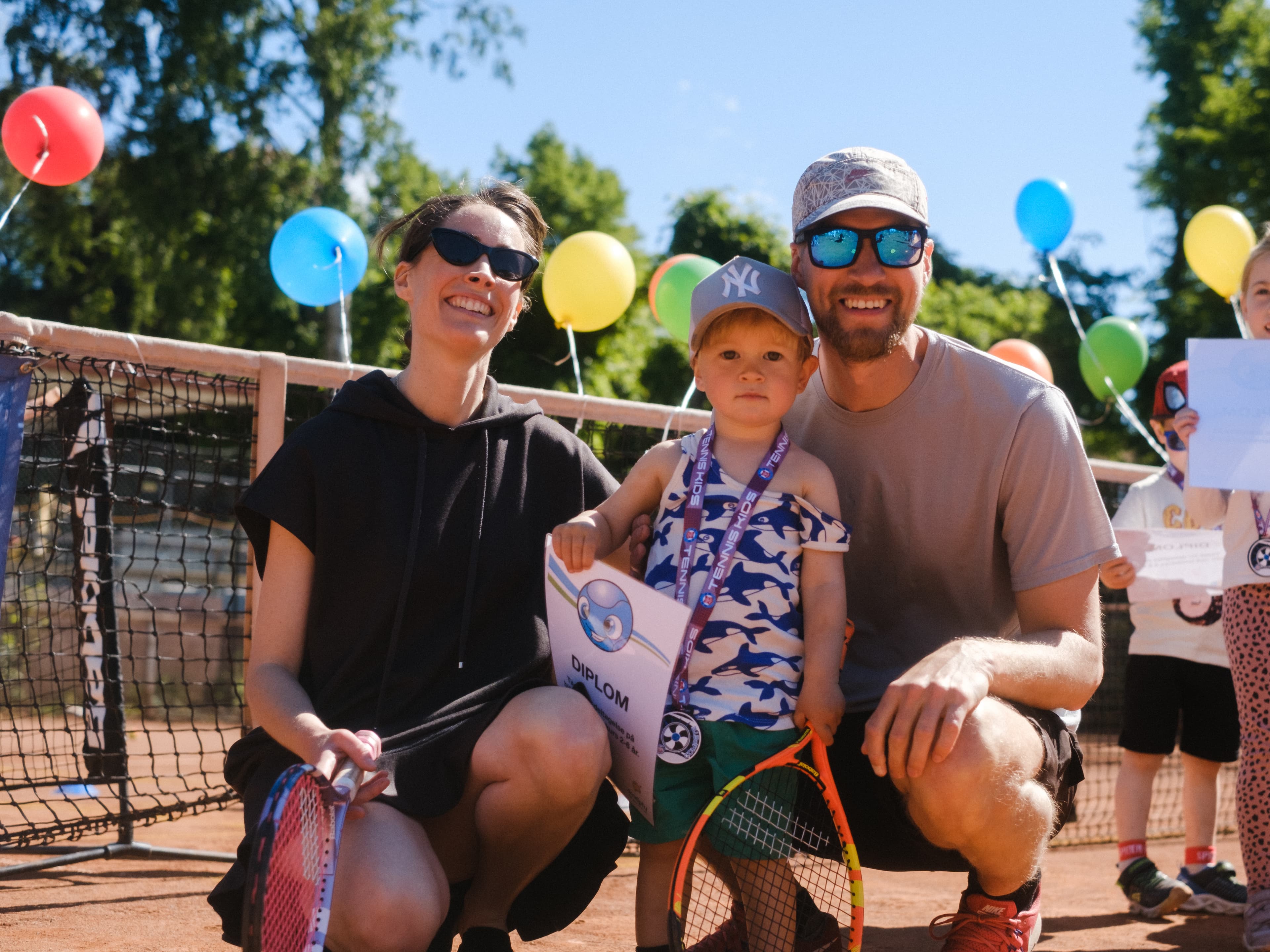 Barn på tenniskurs sammen med en forelder
