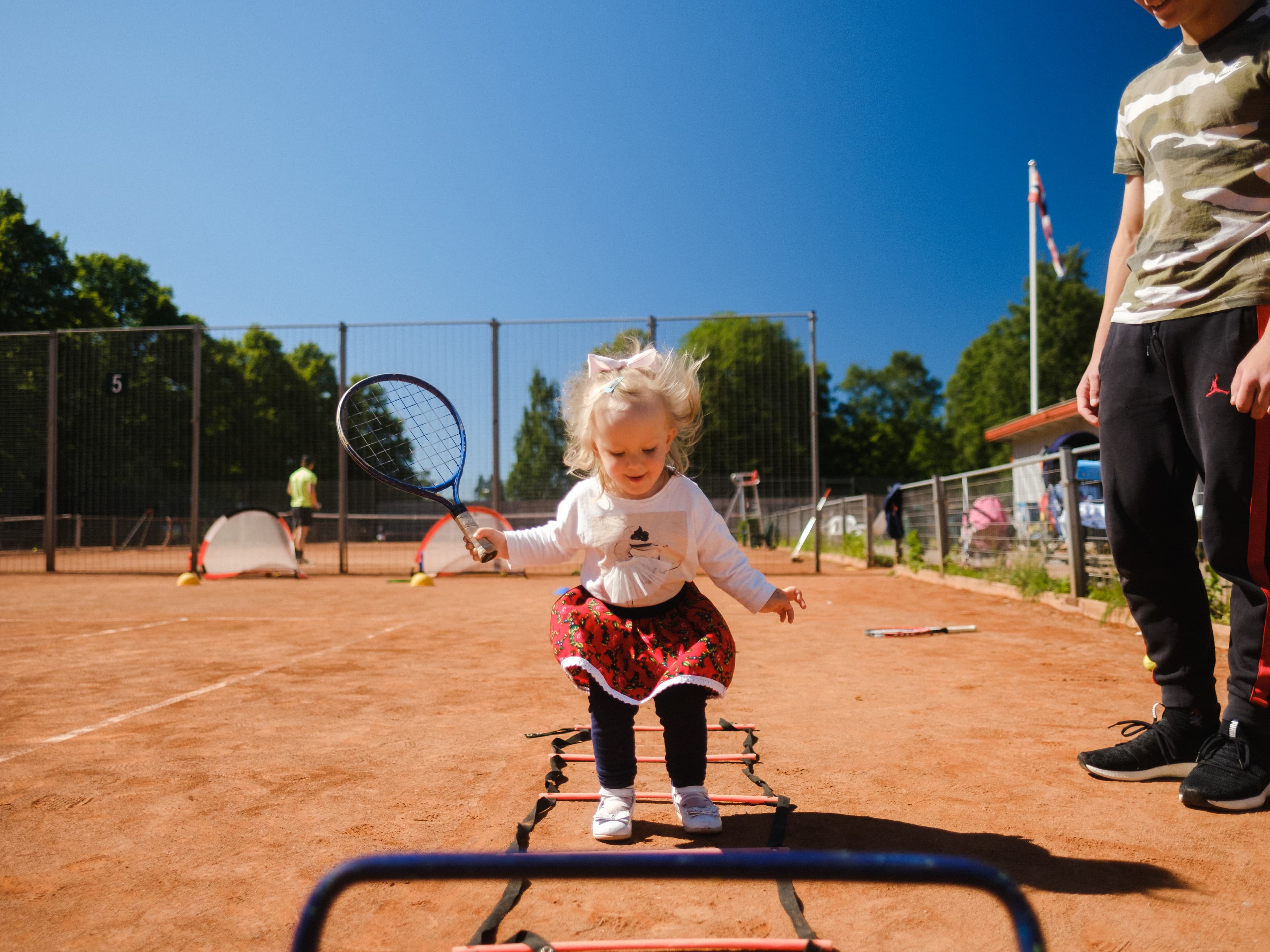 Barn på tennisbanen med utstyr tilpasset barn